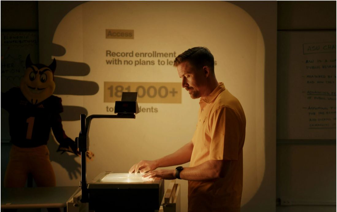 A man placing a slide on a projector which is being displayed on a screen